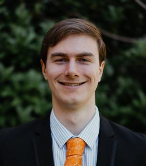 Photograph of Jesse Schelfhout smiling and wearing his favourite (orange) tie